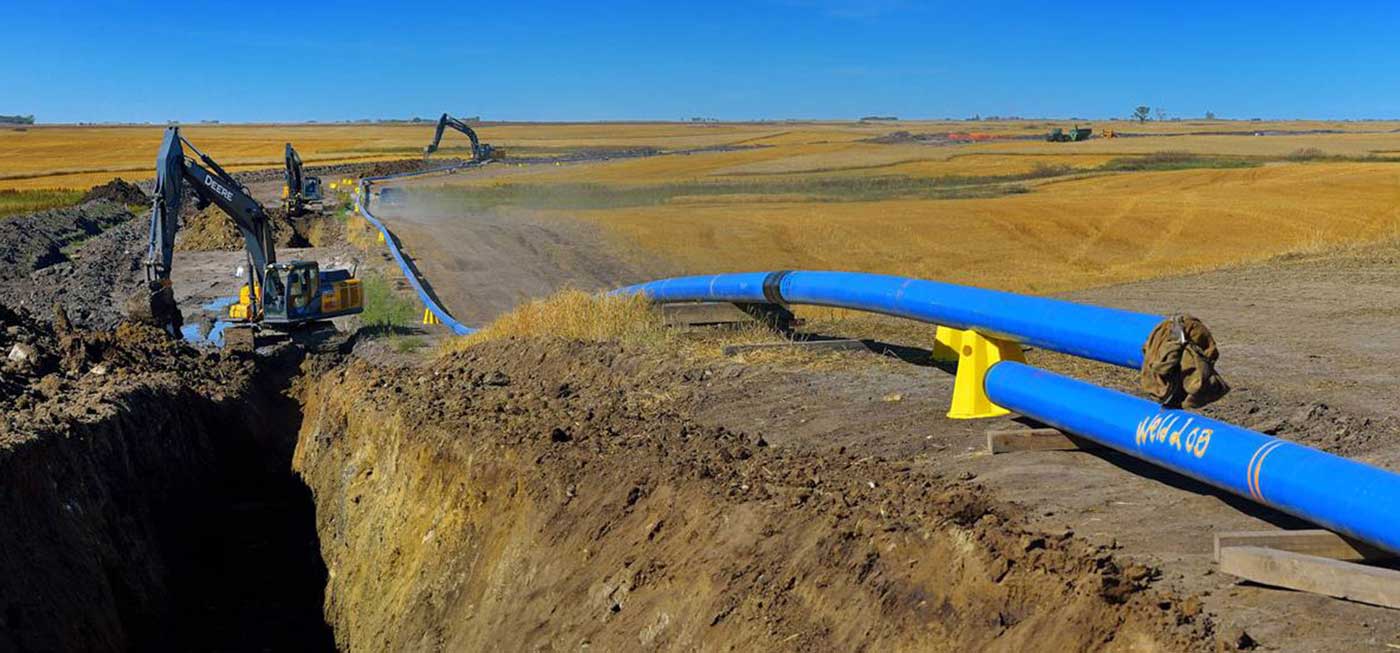 NTL team lays blue pipe for pipeline project in open field